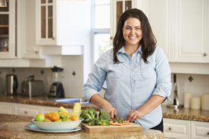 woman preparing food to maintain her weight