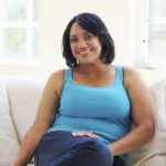 woman sitting on couch with pcos